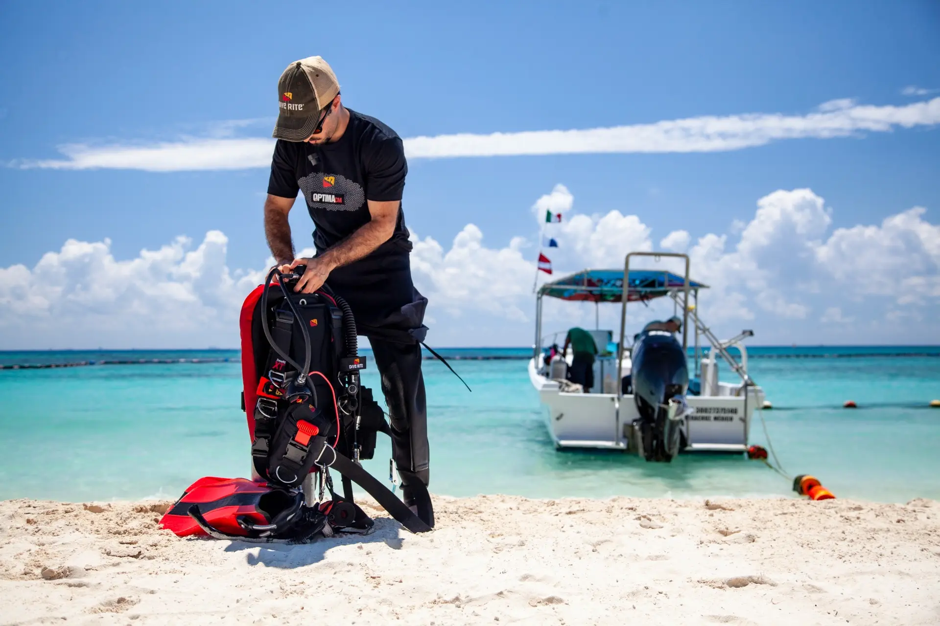 Diver preparing equipment beside a boat in the Mexican Caribbean